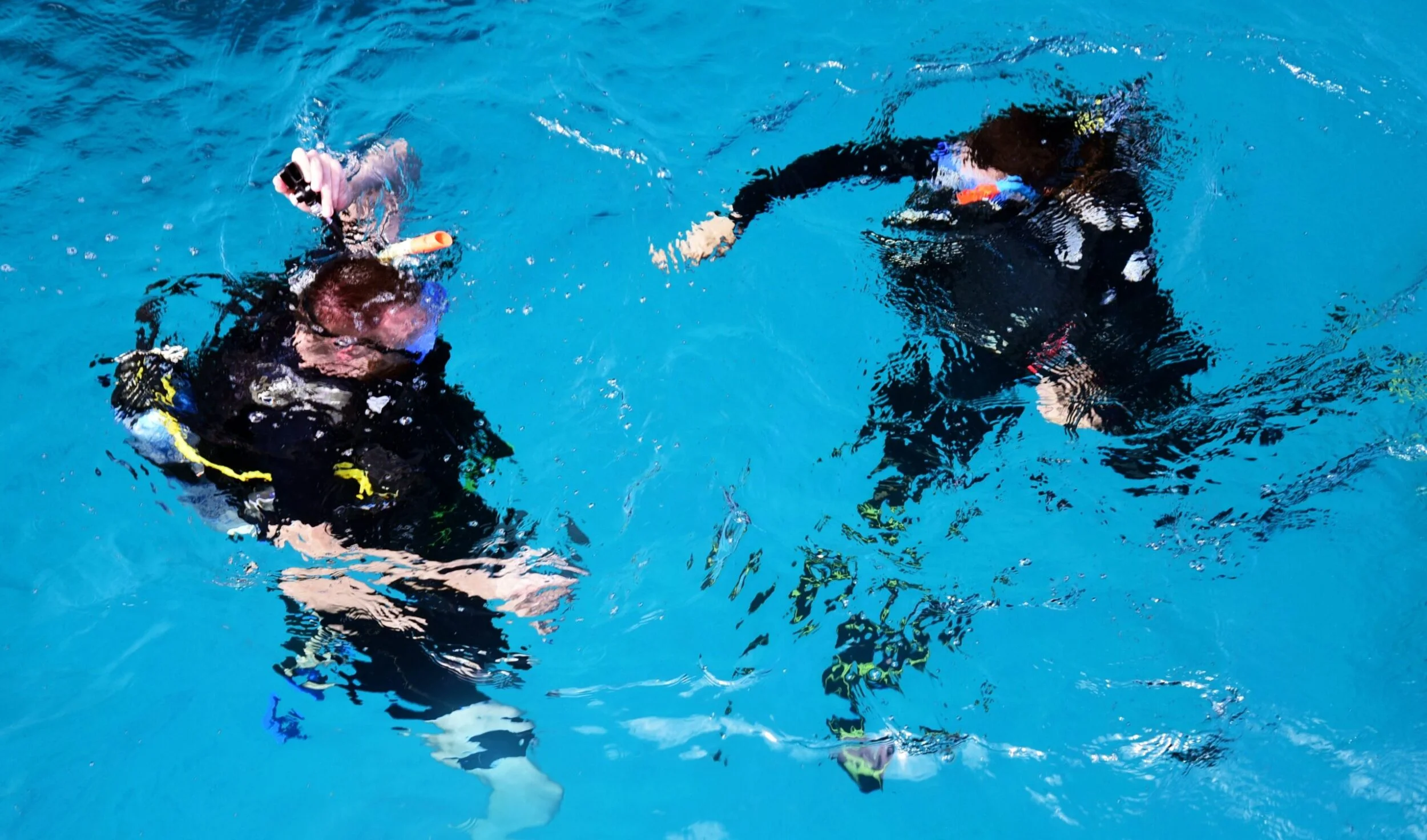 Student performing a buoyancy test while instructor checks if everyting is OK - Photo By Laya Clode on Unsplash