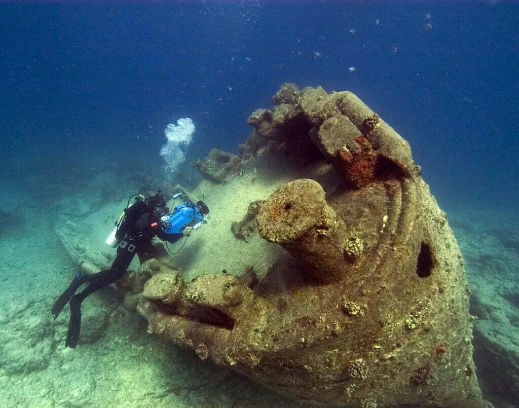 "NOAA diver John Brooks inspecting the remains of the USS MACAW wreck at Midway Island.  - Photo by NOAA at Unsplash"